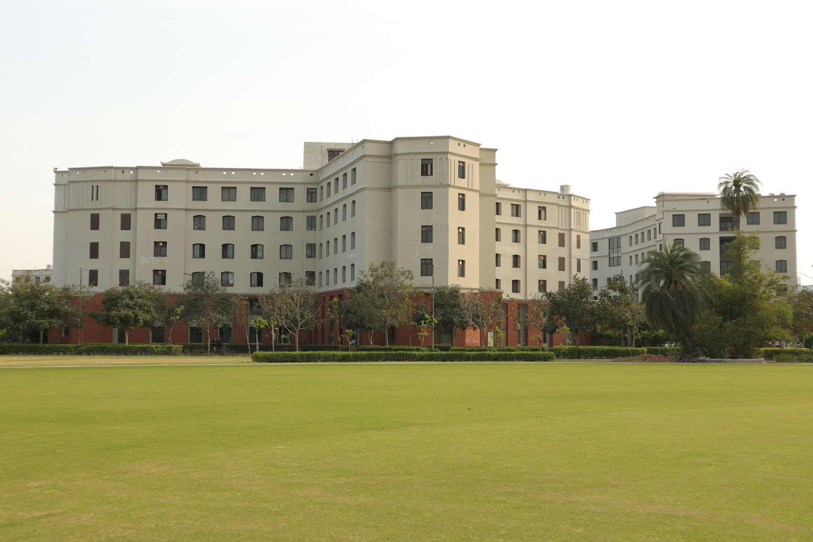 A college building across a wide green lawn.