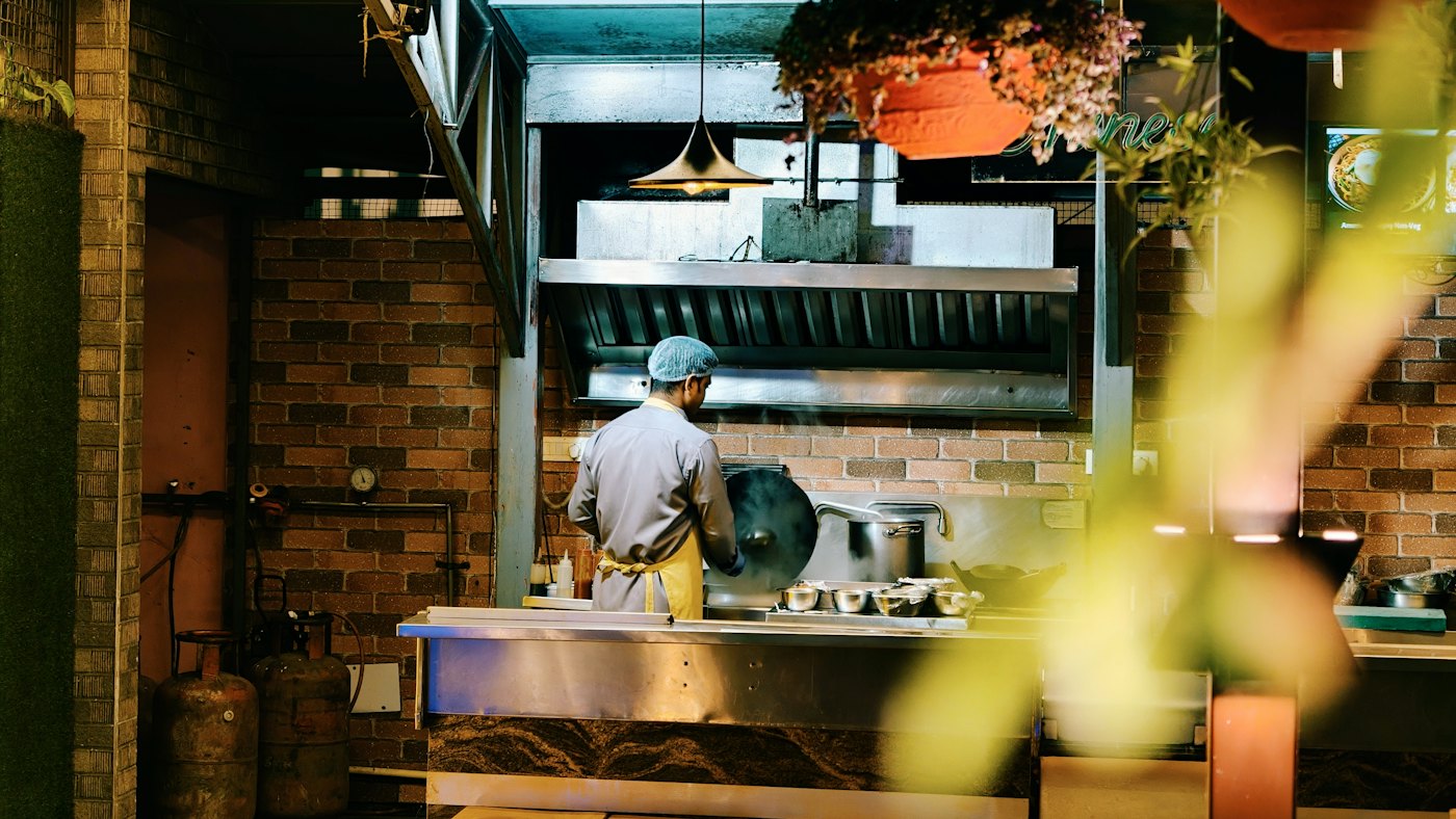 A chef cooking in a restaurant kitchen.