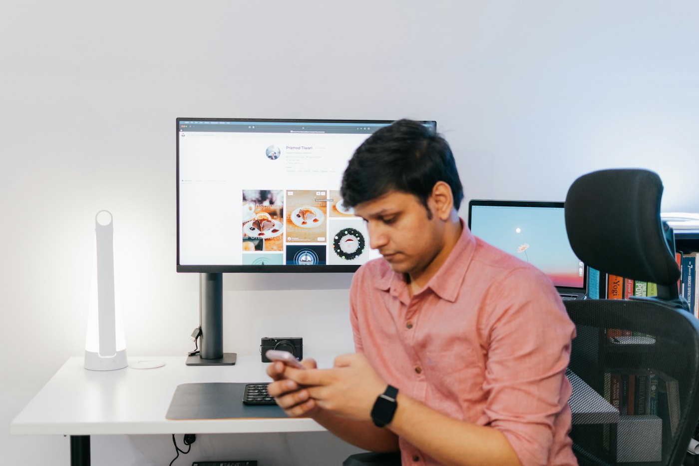 An employee at his desk reading on his phone.