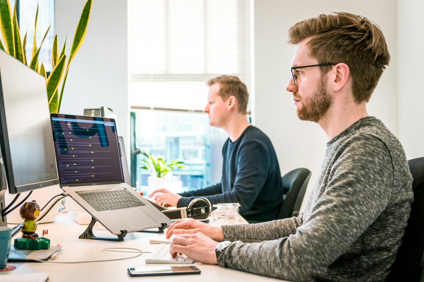 Two engineers at their desks watching monitoring screens.