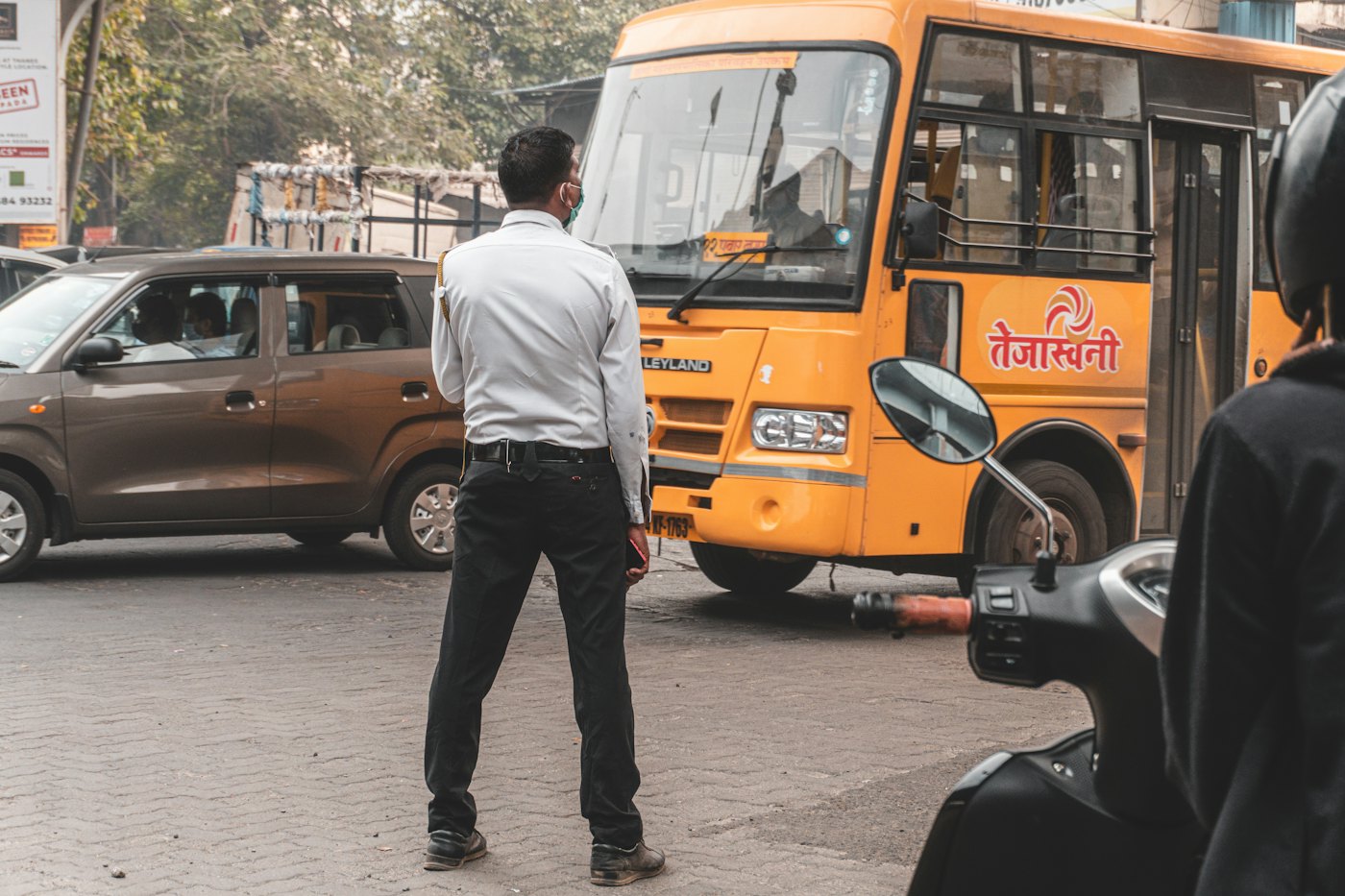 A school bus at a busy street crossing, with the bus, a car and a person detected by the AI camera.